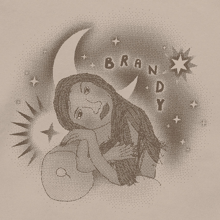 Detail of a tan hoodie featuring a vintage 90s childhood fan art of American singer Brandy. In the artwork, Brandy is reclining on a couch, surrounded by graphic stars and a moon, with handwritten bubble letters spelling out 'BRANDY. © Donny Meloche, 2023.