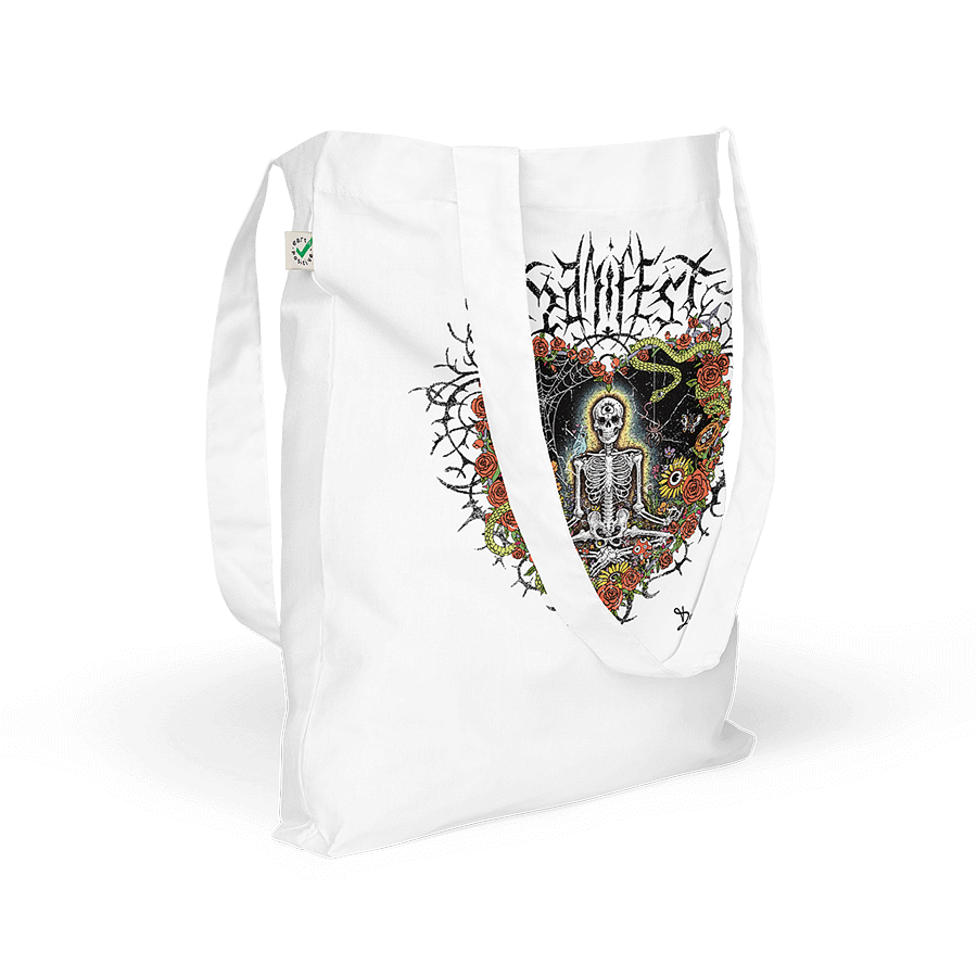 A white organic cotton tote bag featuring a meditating skeleton surrounded by flowers, evoking a vintage metal band tee with a modern, positive twist. Artwork by Donny Meloche, 2023.