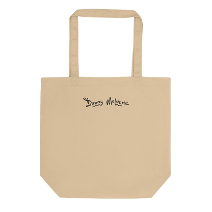 A beige tote bag with a playful logo spelling out the name 'Donny Meloche'. © Donny Meloche, 2023.
