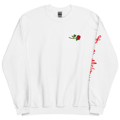 The front of a white sweatshirt with a small illustration of a tilted red rose; placed over the heart on the left side of the chest. © Donny Meloche, 2023.