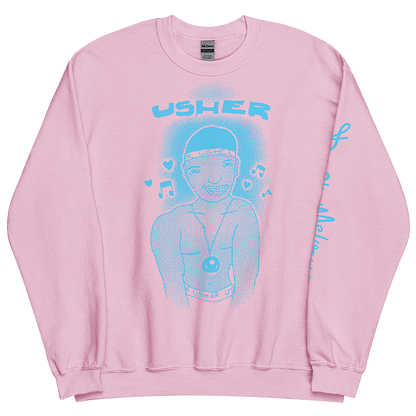 An image of a bubblegum pink sweatshirt with a baby blue graphic featuring a childlike illustration of American R&B music singer, Usher Raymond. He stands smiling with a chain around his neck and musical notes around his head. © Donny Meloche, 2023.